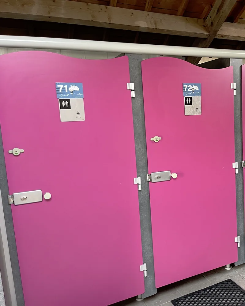 Les portes roses des cabines 71 et 72, avec les pictogrammes douche et WC