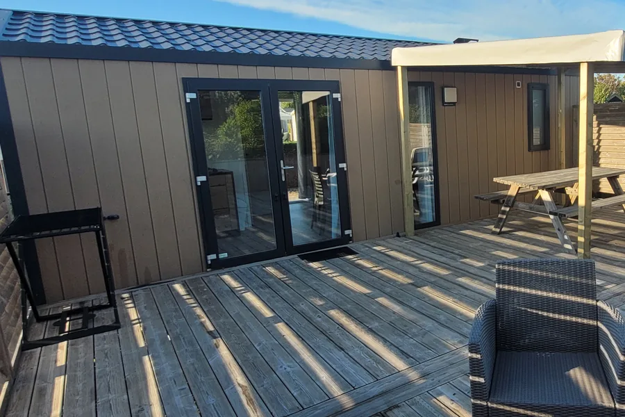 Le mobil-home Fidji et sa grande terrasse en bois, avec transats, table de pique-nique et pergola