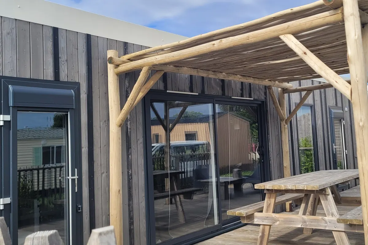 Un mobil-home en bois avec pergola et grande terrasse